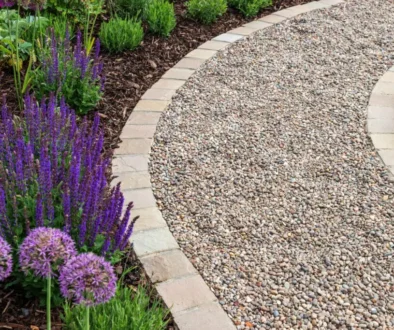 Gravel path with stone borders defining garden space.