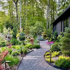 Ukrivljena gramozna pot z obrobo iz naravnega kamna na vrtu.